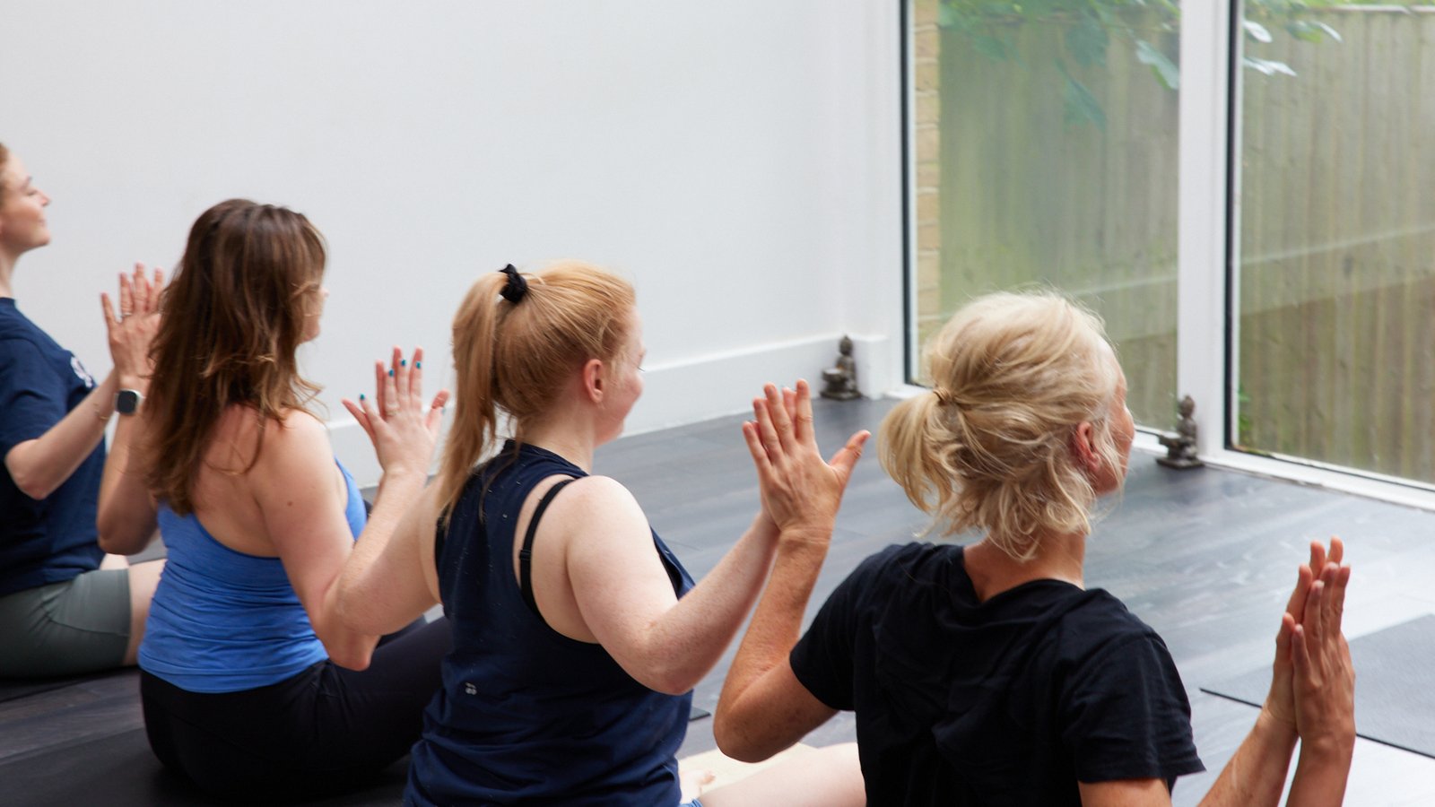 Phoenix Yoga community members raising their hands together